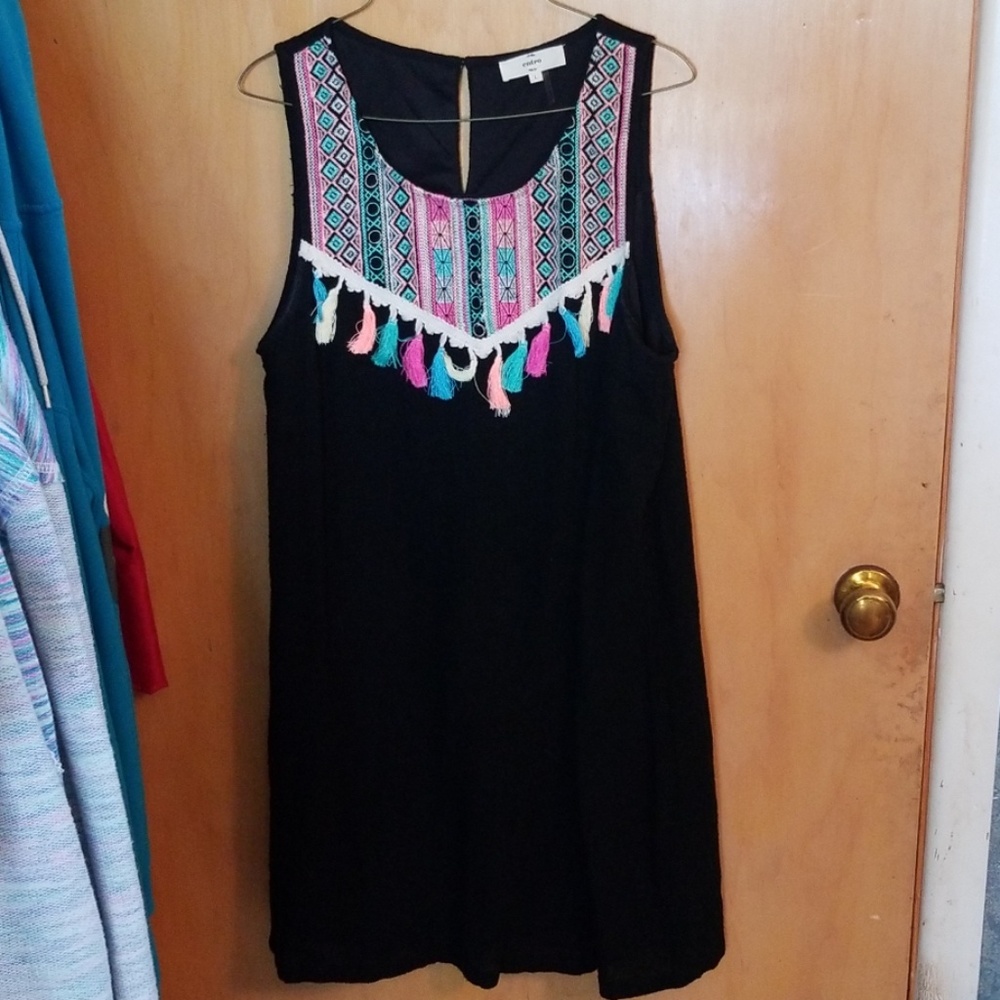 Black dress with colorful embroidery and tassels.